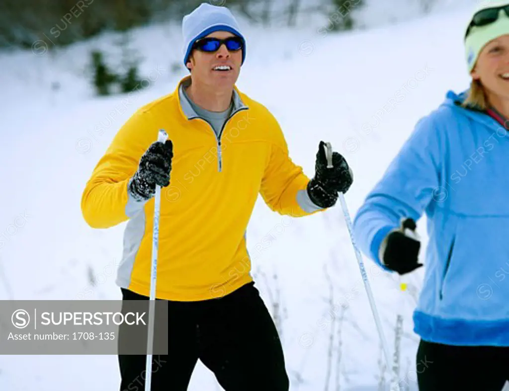 Young man and a mid adult woman skiing