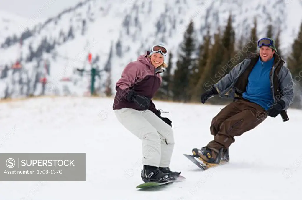 Mid adult couple snowboarding