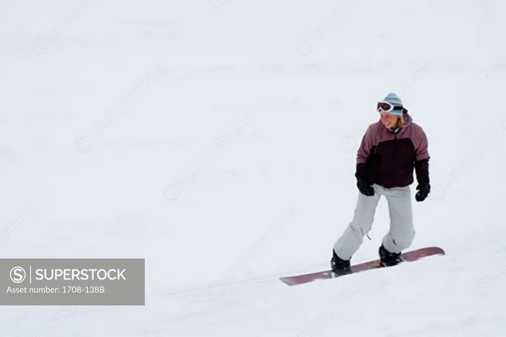 Mid adult woman snowboarding