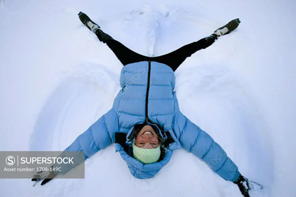High angle view of a mid adult woman lying in the snow