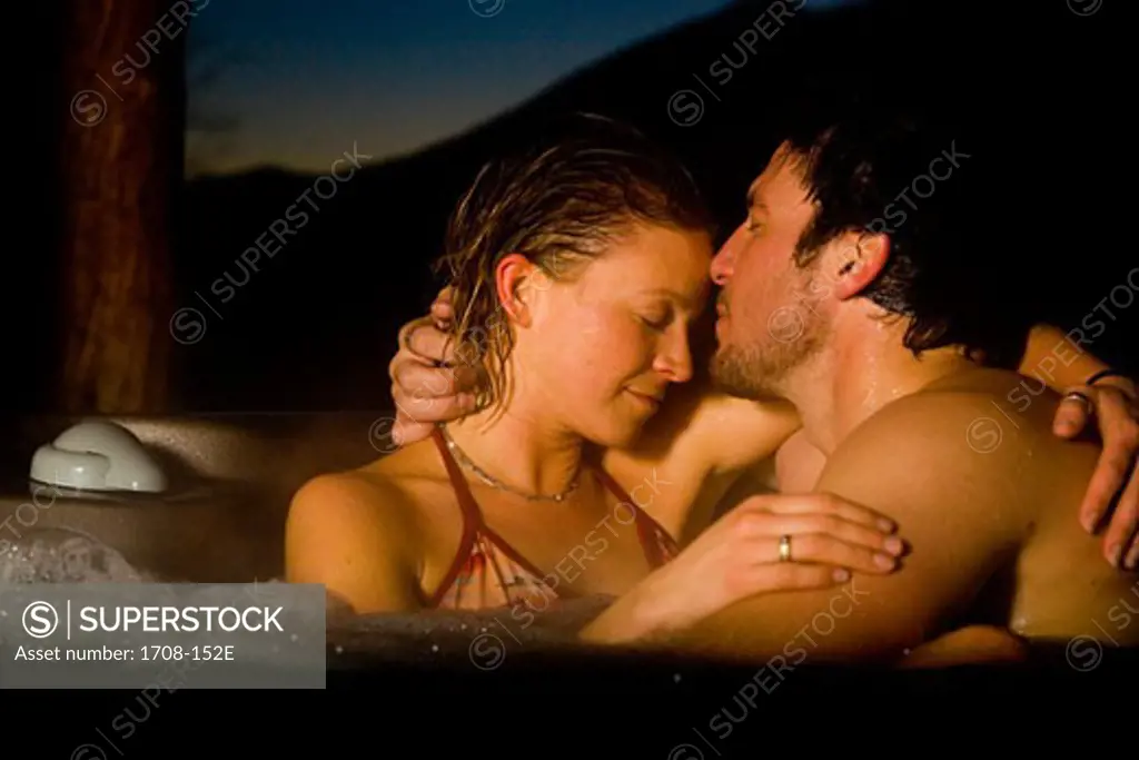 Mid adult couple embracing in a hot tub