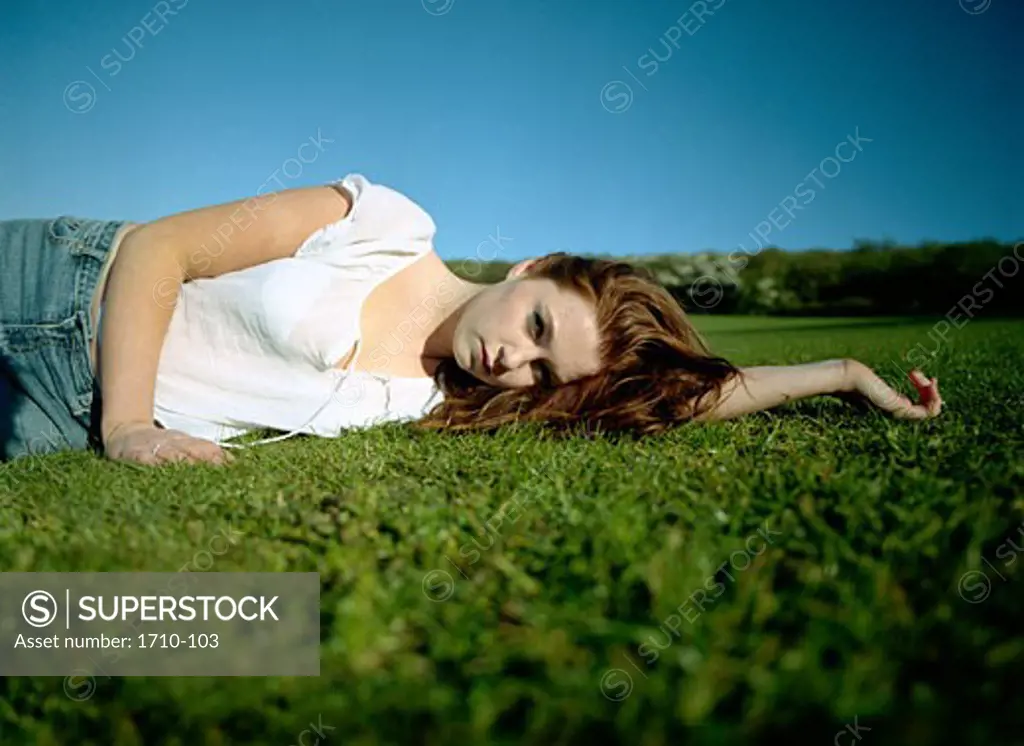 Mid adult woman lying on the grass in a park