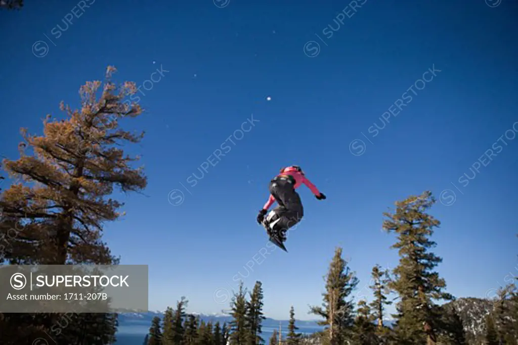 Low angle view of a young woman snowboarding