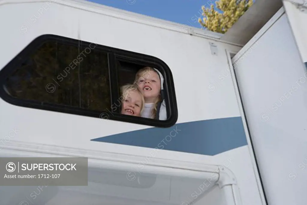 Low angle view of two girls in a recreational vehicle