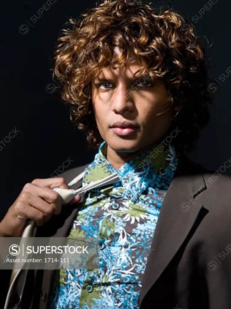 Portrait of a young man unknotting his tie