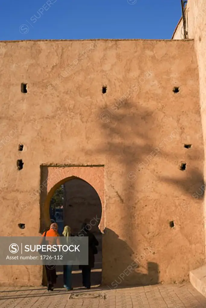 Tourists entering under an archway in a fortified wall, Marrakesh, Morocco