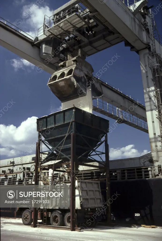 Rock salt being loaded onto a truck from an industrial ship