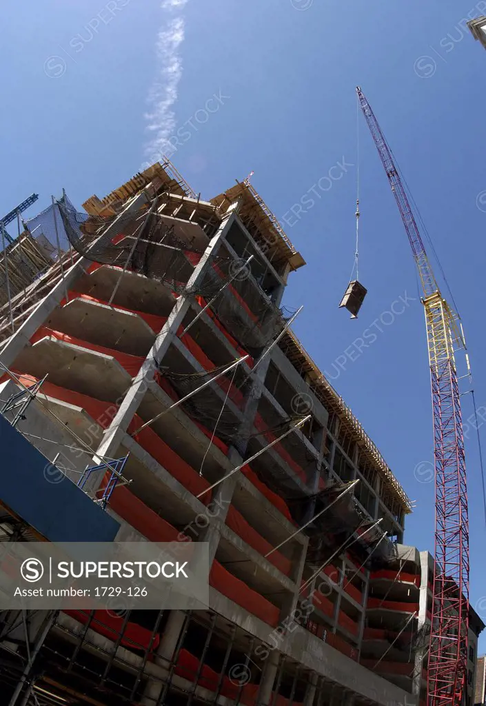 Low angle view of a crane at an apartment building construction site