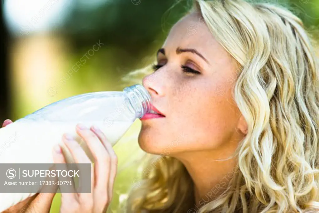 Young woman drinking milk from the bottle