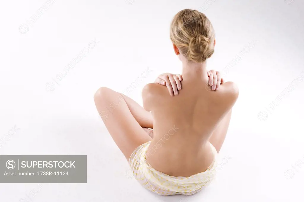 Rear view of a woman massaging her shoulders