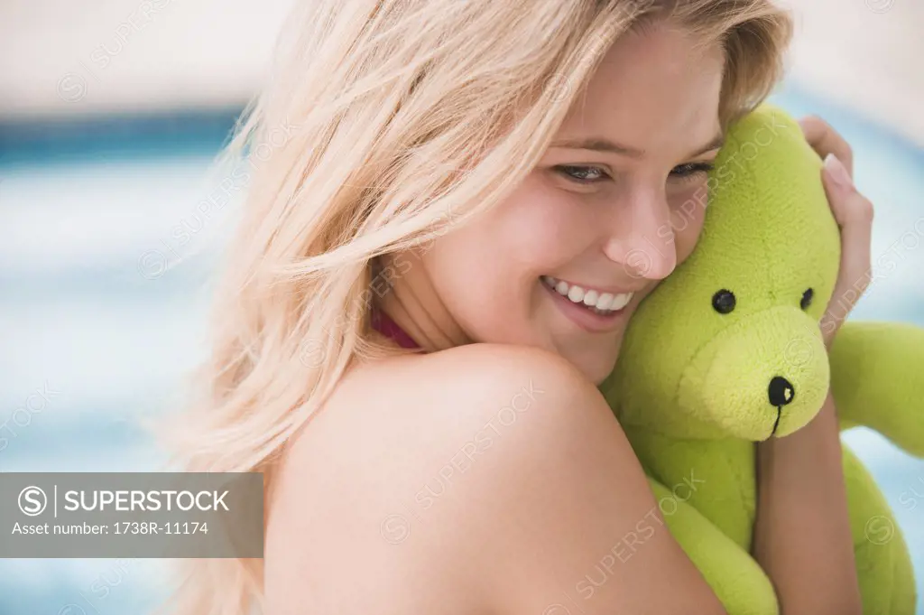 Close-up of a woman holding a teddy bear and smiling