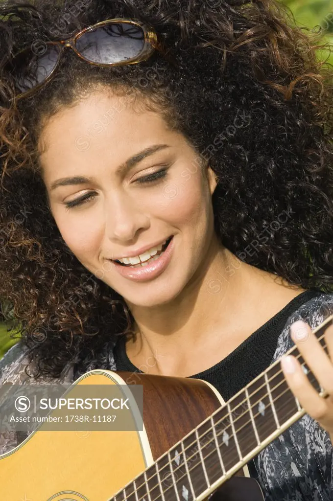 Woman playing a guitar and smiling