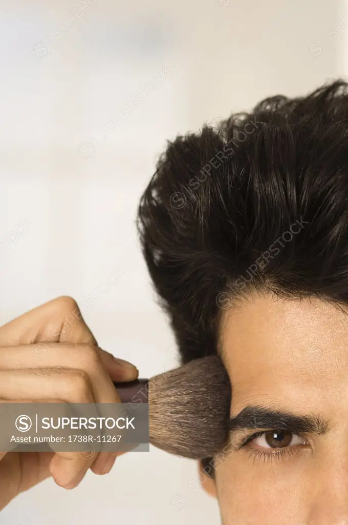 Man applying blush on his temple