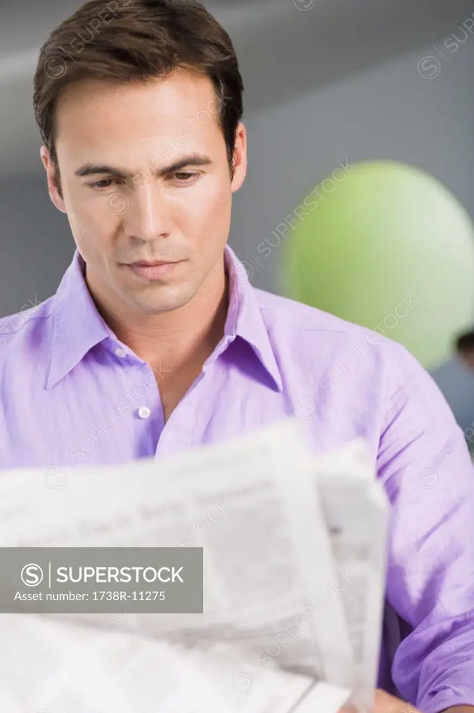 Close-up of a man reading a newspaper