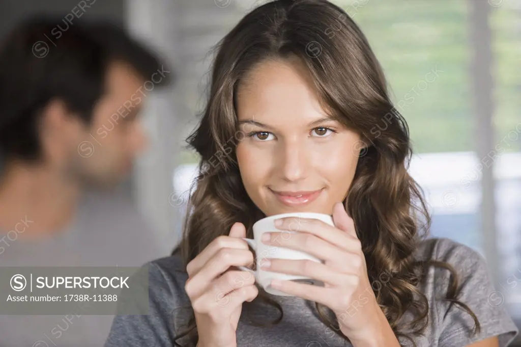 Woman holding a cup of tea and day dreaming