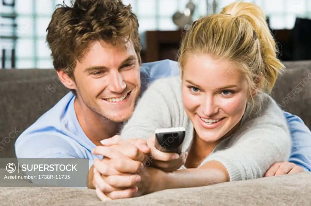 Couple holding a remote control and smiling