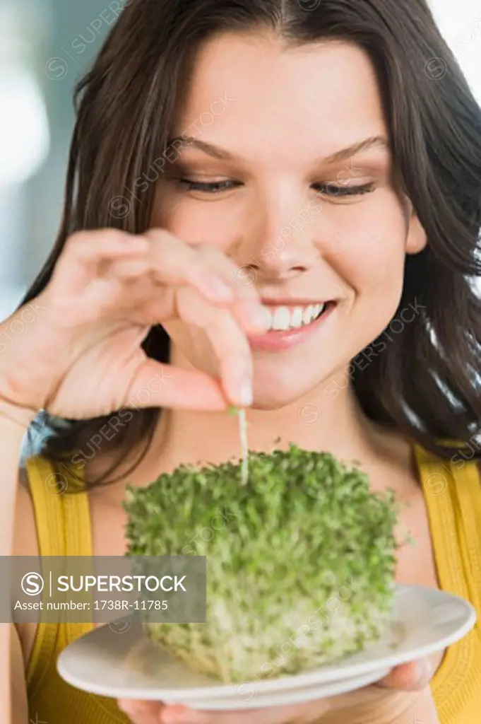 Woman eating bean sprouts and smiling