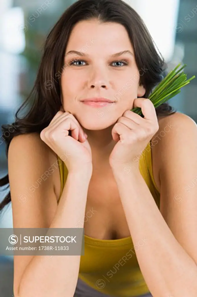 Portrait of a woman holding chives