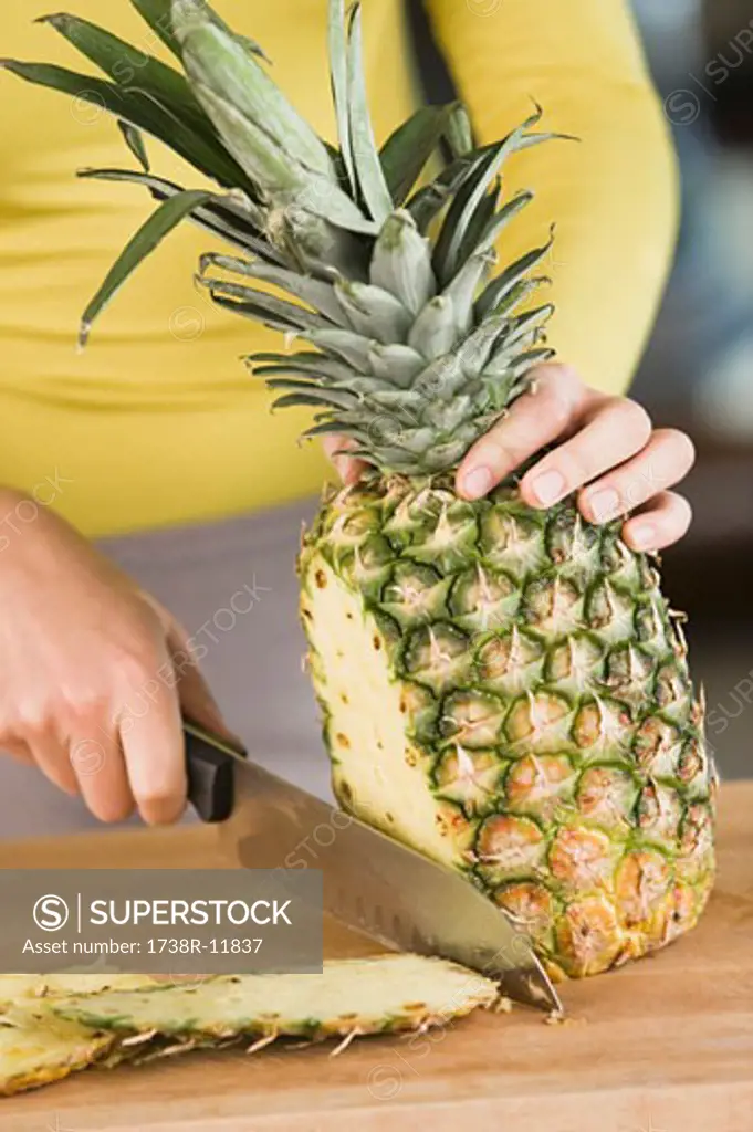 Woman cutting a pineapple