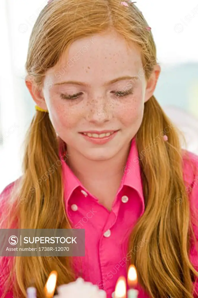 Close-up of a girl looking at a birthday cake