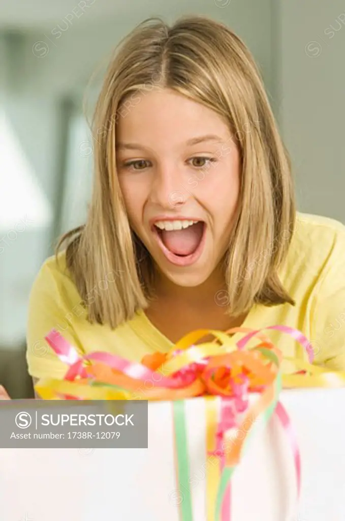 Girl looking at a birthday present with a surprise