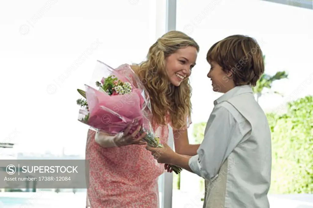 Boy giving a bouquet of flowers to her mother