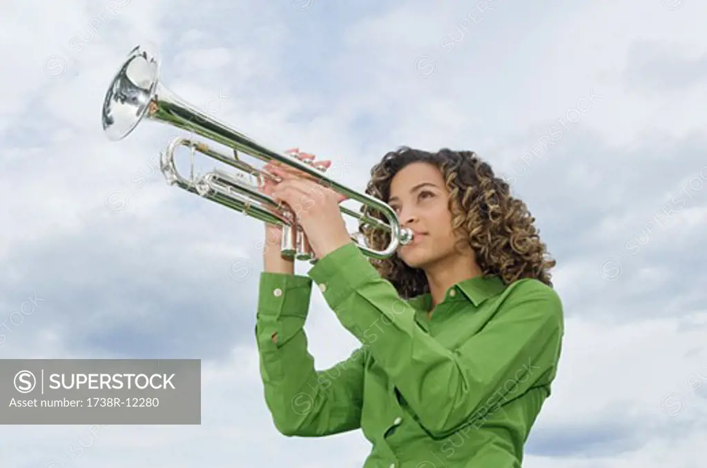 Low angle view of a girl playing a trumpet