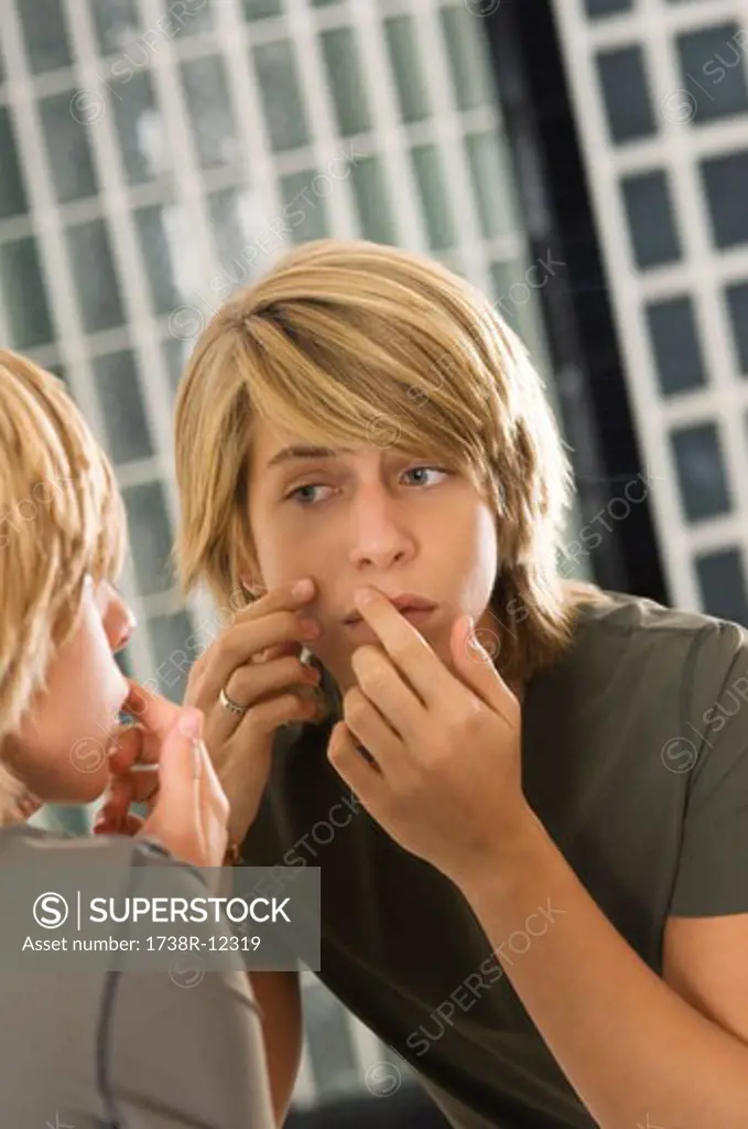 Teenage boy looking at himself in a mirror