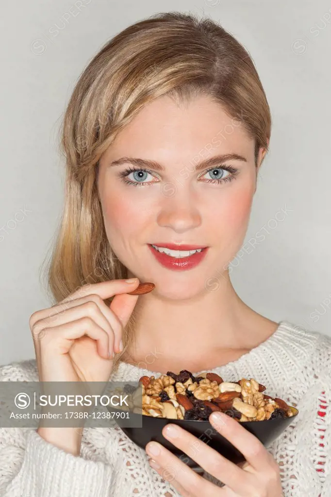 Portrait of a beautiful woman eating dried fruit