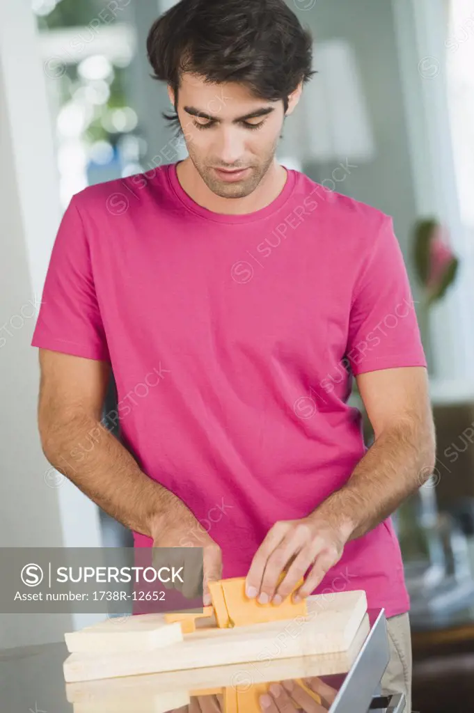 Man cutting cheese slices