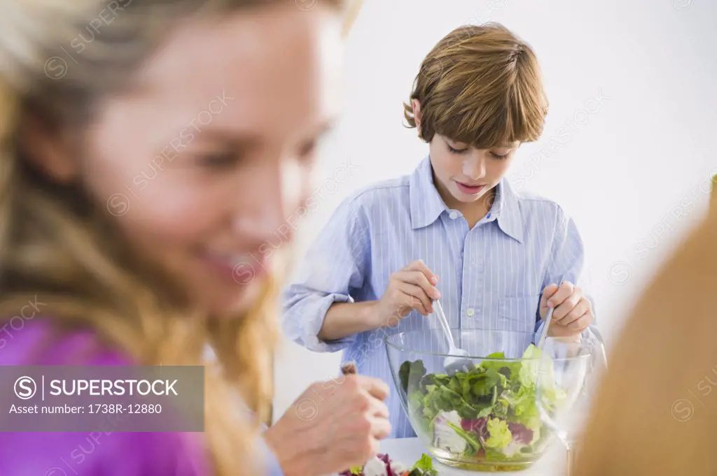 Boy mixing salad in a bowl