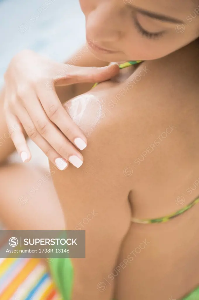 Woman applying moisturizer on her shoulder
