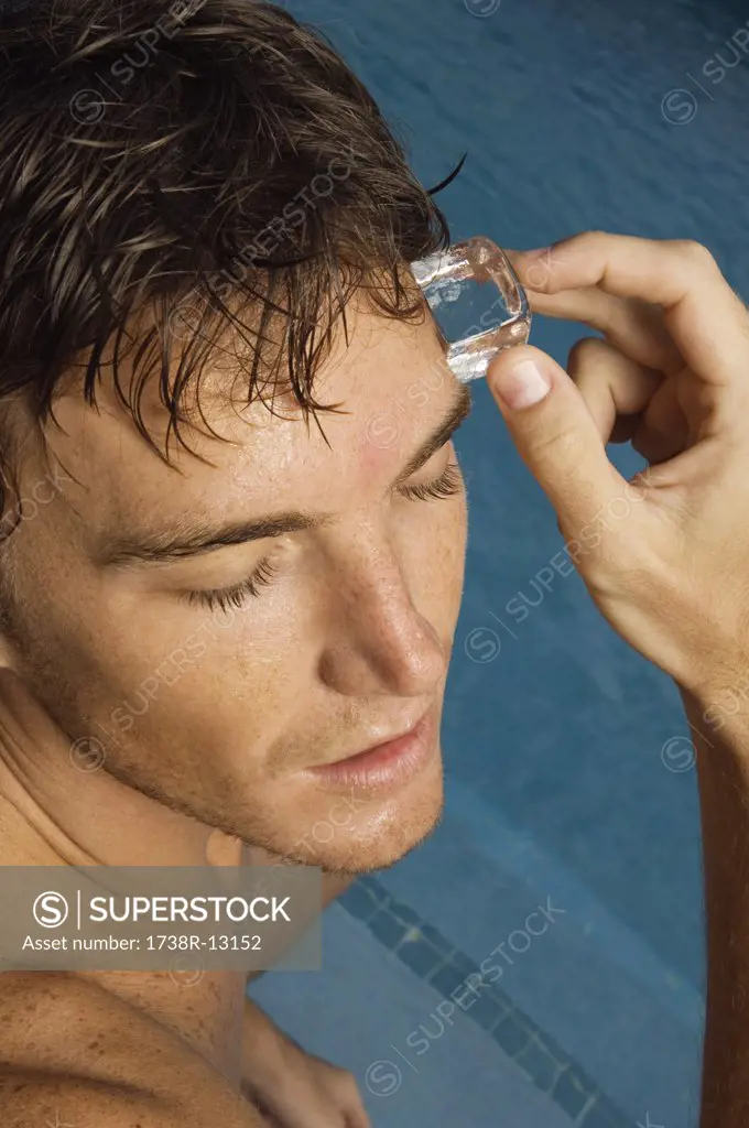 Man rubbing an ice cube on his forehead