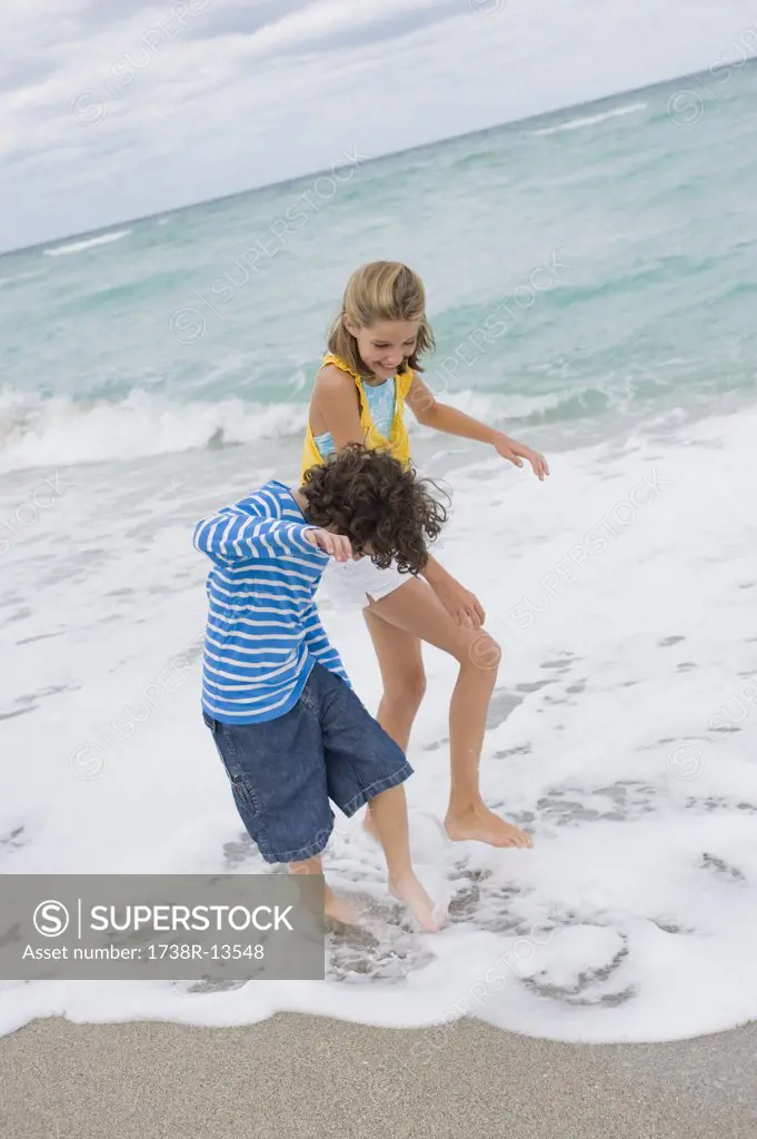 Boy playing with a girl on the beach