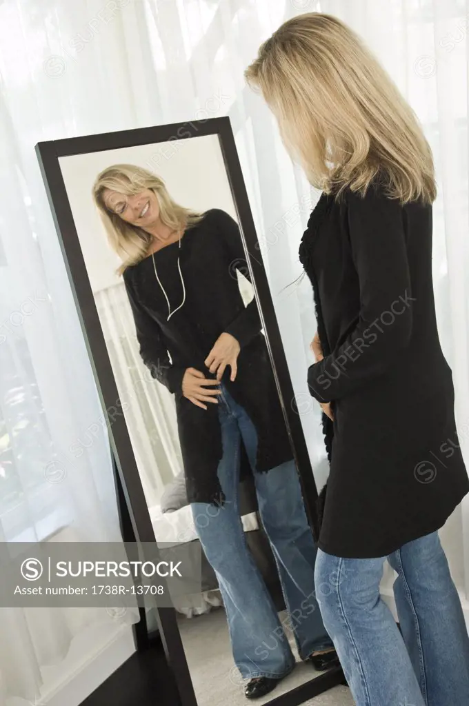 Woman trying on a dress in front of a mirror