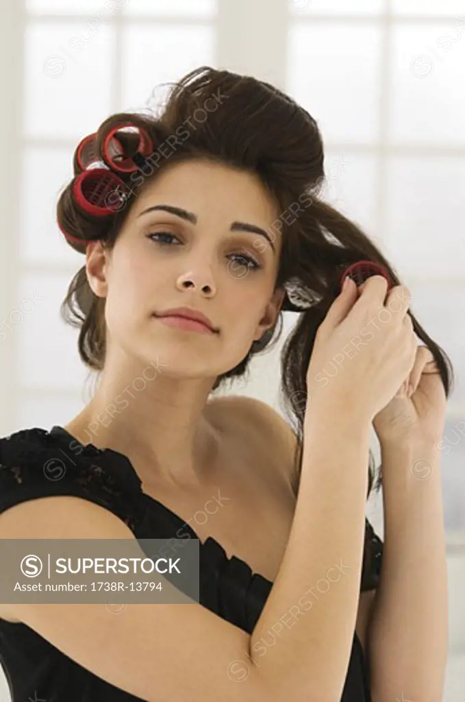 Portrait of a woman removing hair curlers