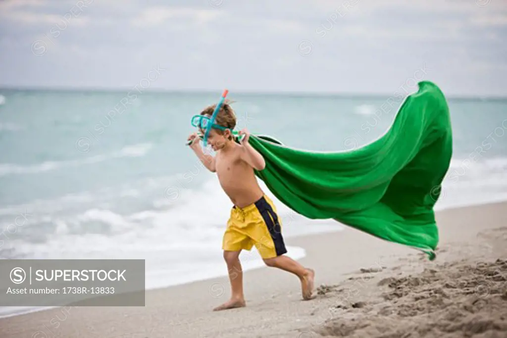 Boy wearing a scuba mask and running on the beach