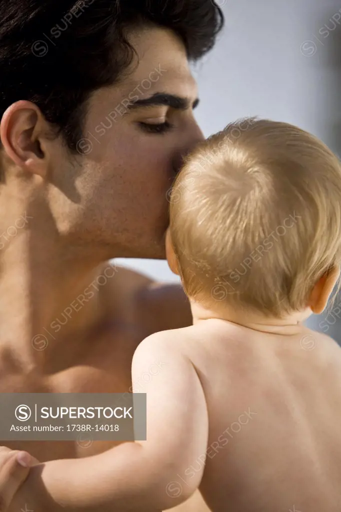 Close-up of a man kissing his son