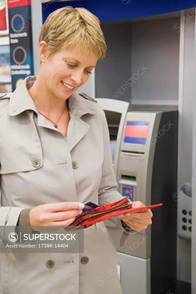 Woman putting a credit card into her wallet and smiling