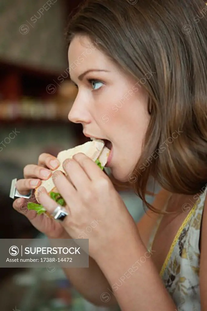 Woman eating sandwich in a cafe