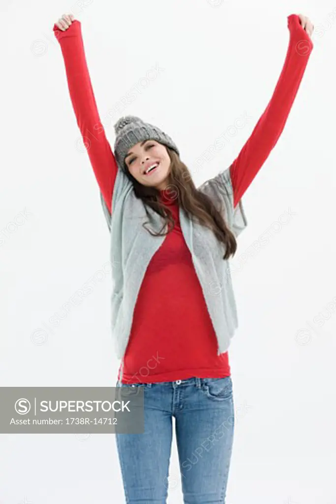Woman standing with her arms raised and smiling