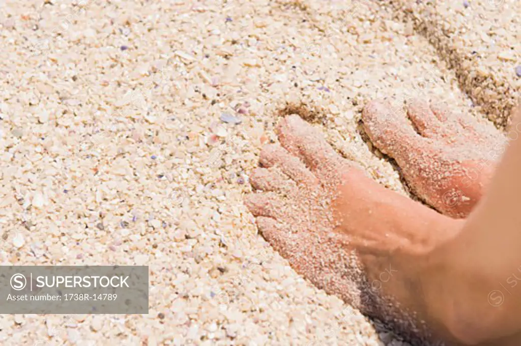 Close-up of man's feet on sand