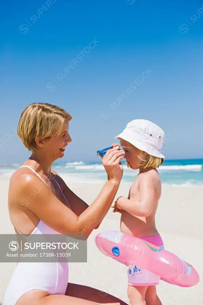 Woman putting on sunglasses on her daughter's face