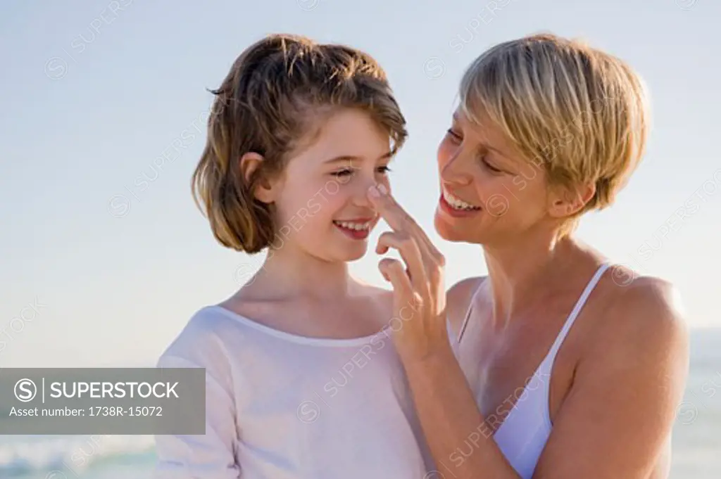 Woman with her daughter enjoying vacations on the beach