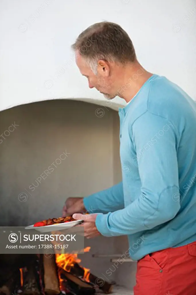 Man cooking kebab in fireplace