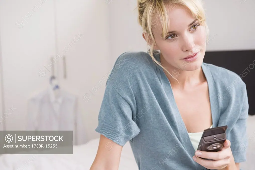Woman holding a mobile phone and thinking