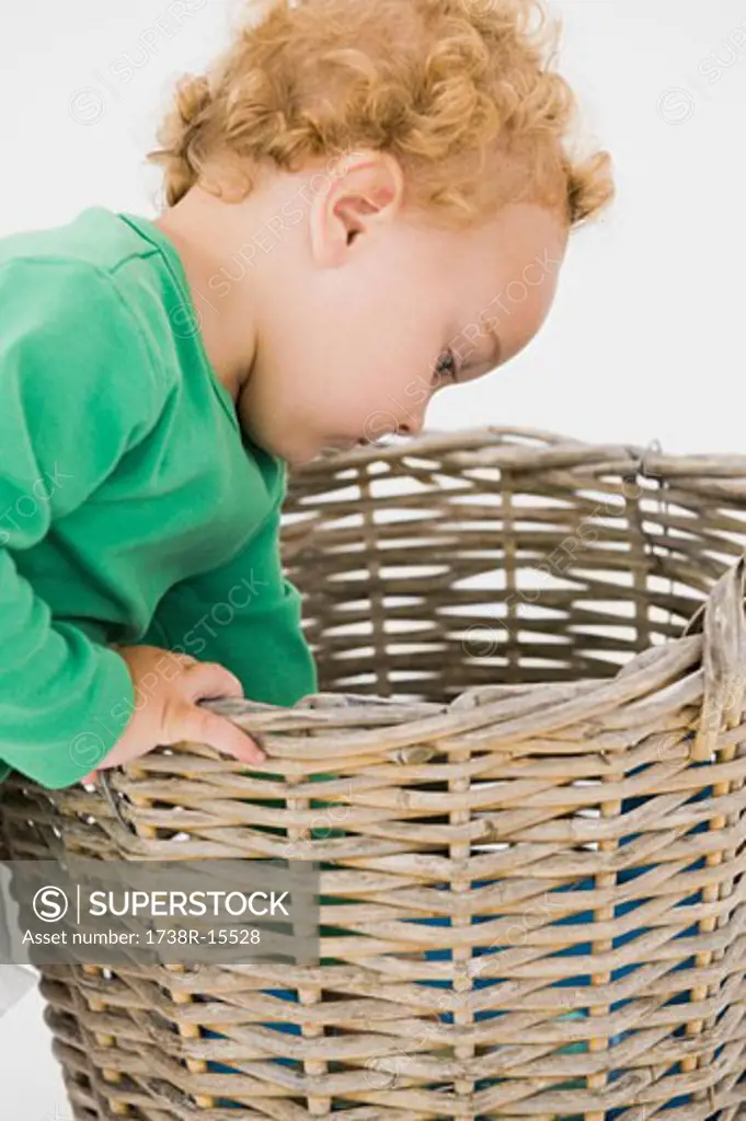 Baby boy looking into a wicker basket
