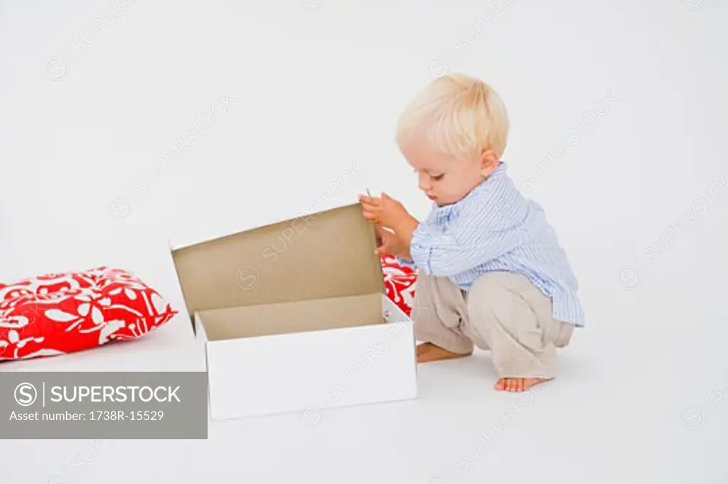 Baby boy opening a box