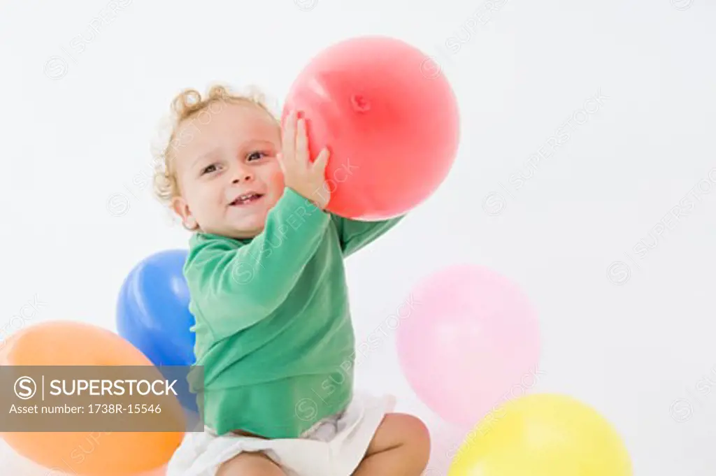 Baby boy playing with balloons