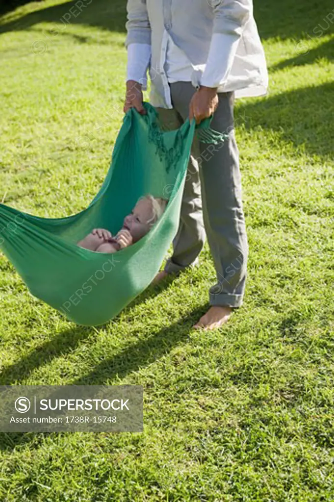 Low section view of a man swinging his daughter